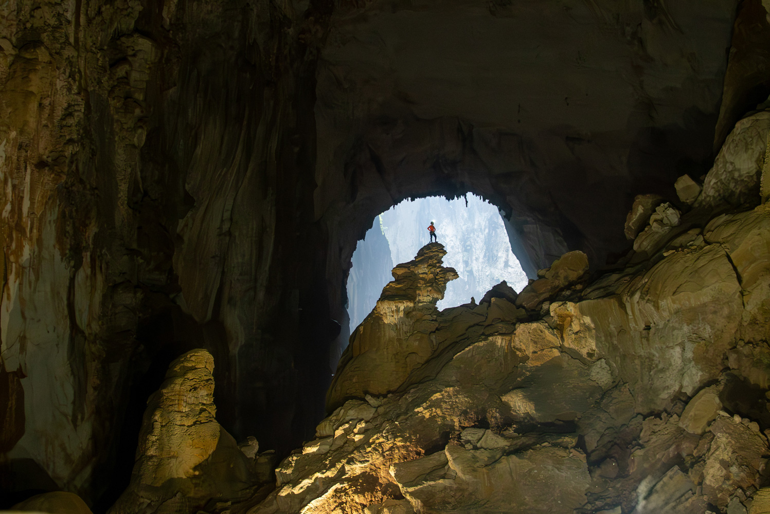 A caver stands atop an enormous stalagmite inside Hang Son Doong. A caver stands atop an enormous stalagmite inside Hang Son Doong.